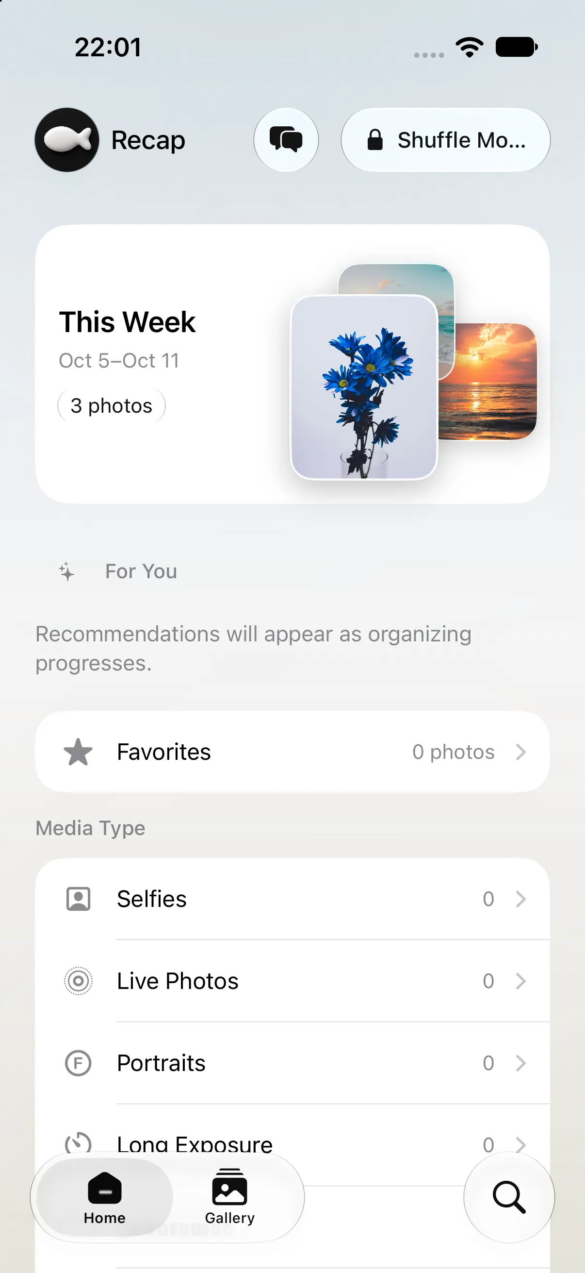 A hand holding a front-facing phone displaying Recap’s real home screen and this week’s photo card.